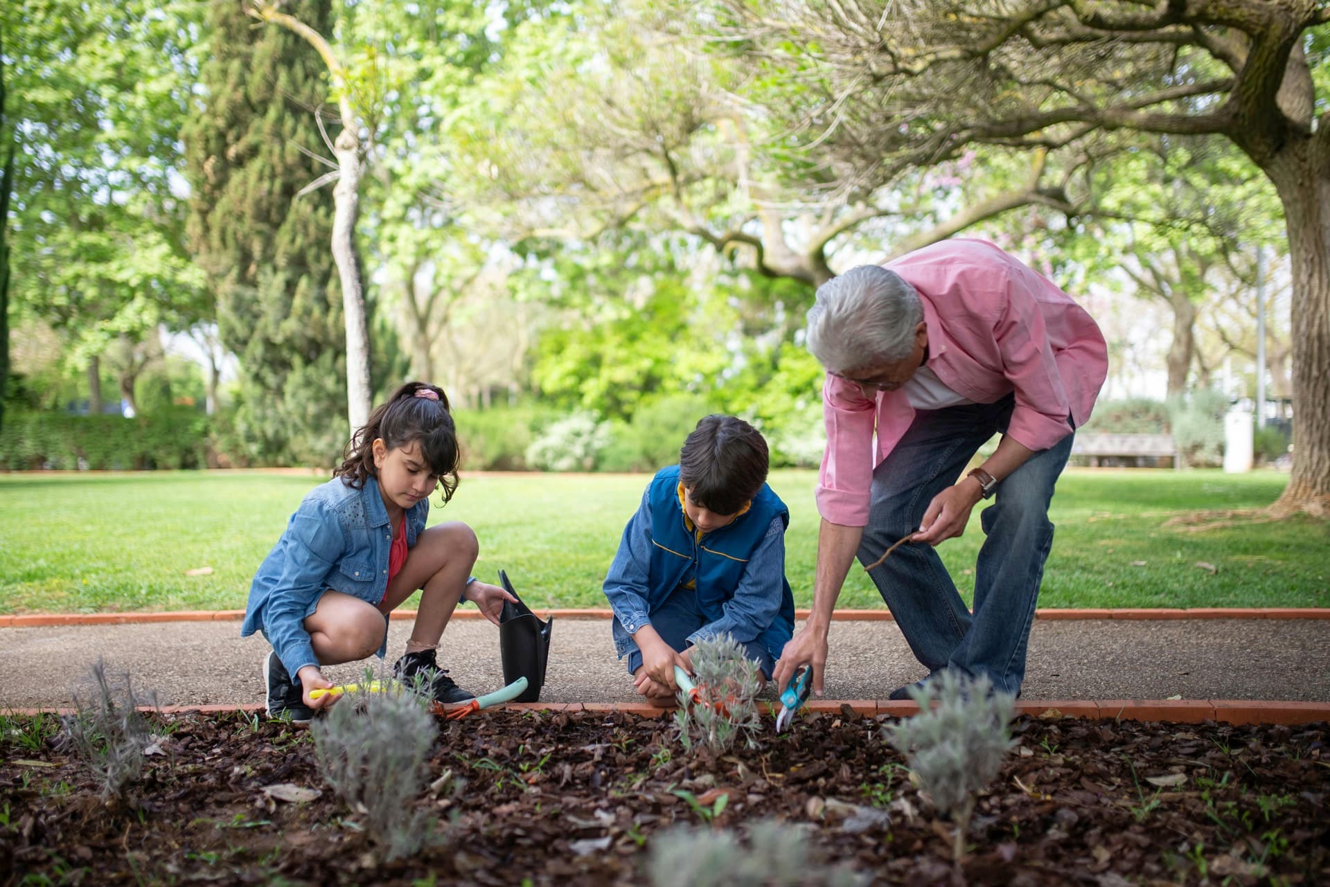 Family gardening together in spring sunshine.
